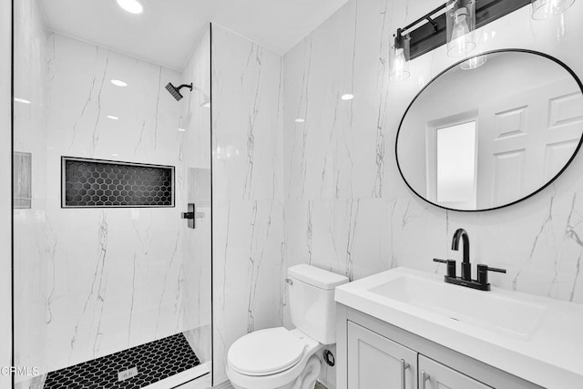 bathroom with vanity, toilet, tile walls, and a tile shower