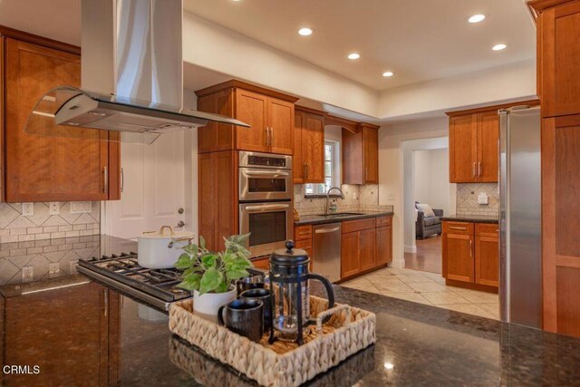 kitchen featuring sink, light tile patterned floors, appliances with stainless steel finishes, tasteful backsplash, and island exhaust hood