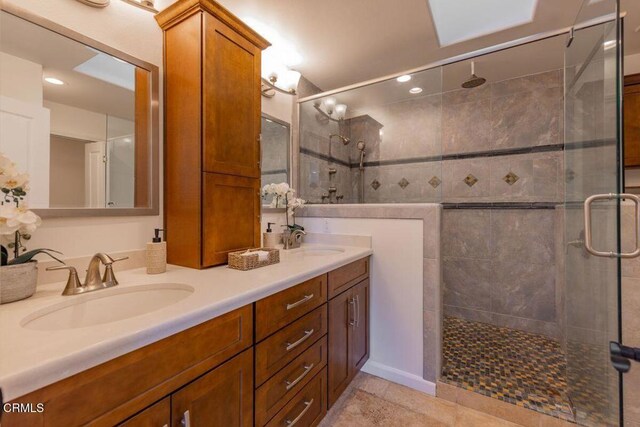 bathroom featuring tile patterned flooring, vanity, and walk in shower