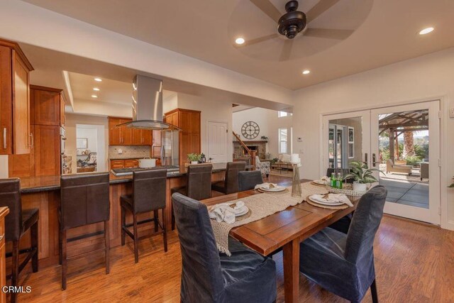 dining space with hardwood / wood-style flooring, ceiling fan, and french doors