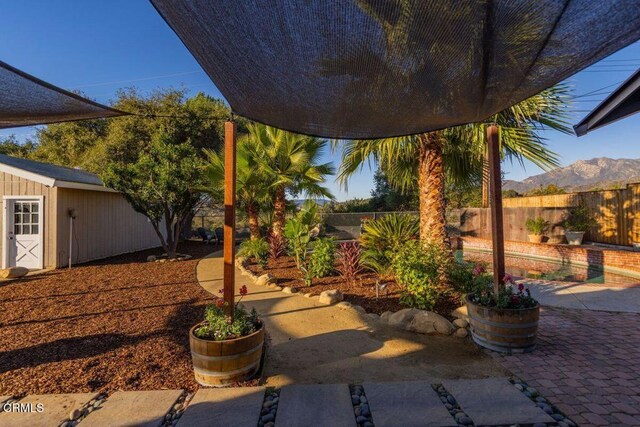 view of patio with a mountain view and a storage unit