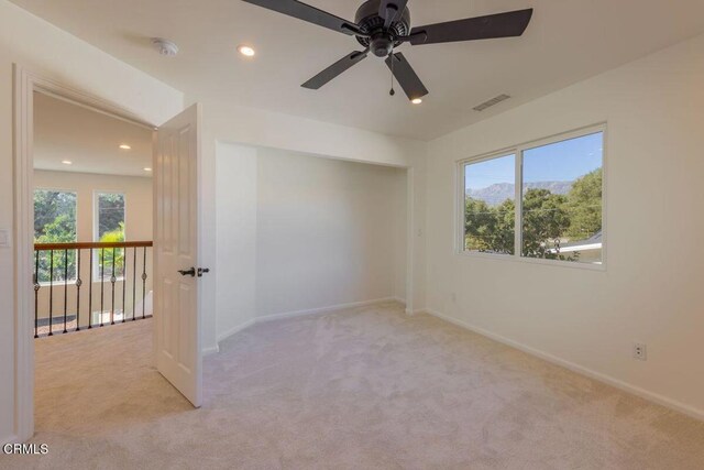 empty room featuring light carpet and ceiling fan