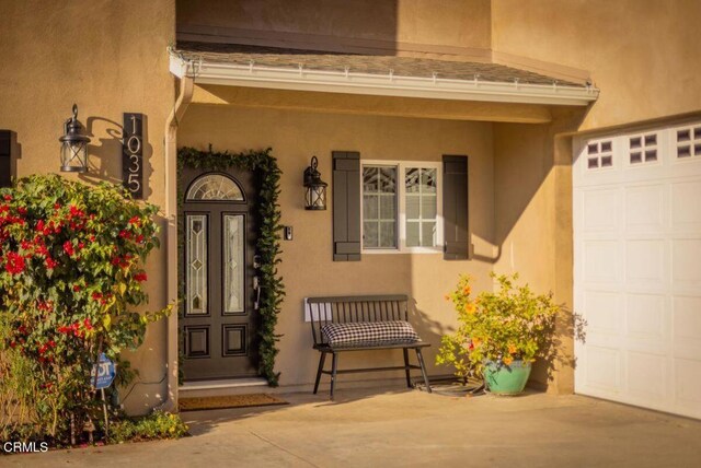 property entrance with a porch and a garage