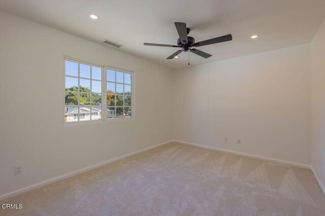 carpeted empty room featuring ceiling fan