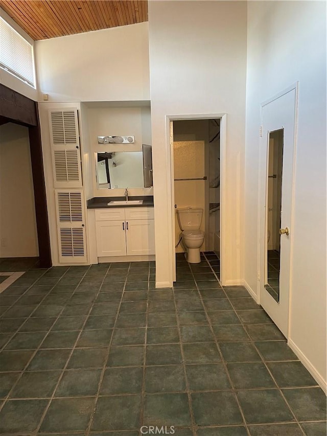 bathroom with vanity, toilet, a towering ceiling, and wooden ceiling