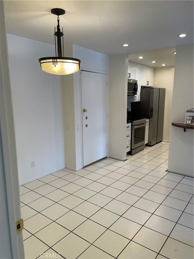 kitchen featuring pendant lighting, light tile patterned floors, white cabinetry, and appliances with stainless steel finishes