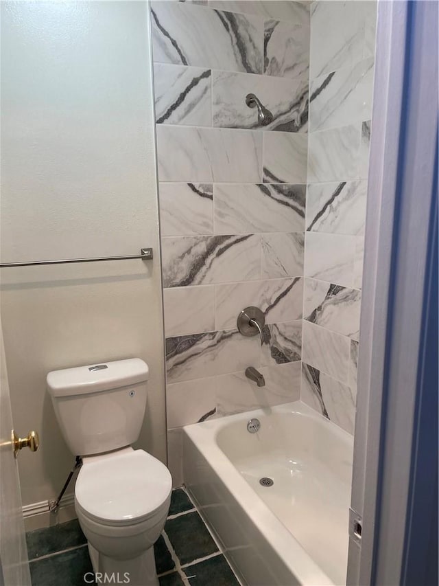 bathroom with tile patterned flooring, toilet, and tiled shower / bath