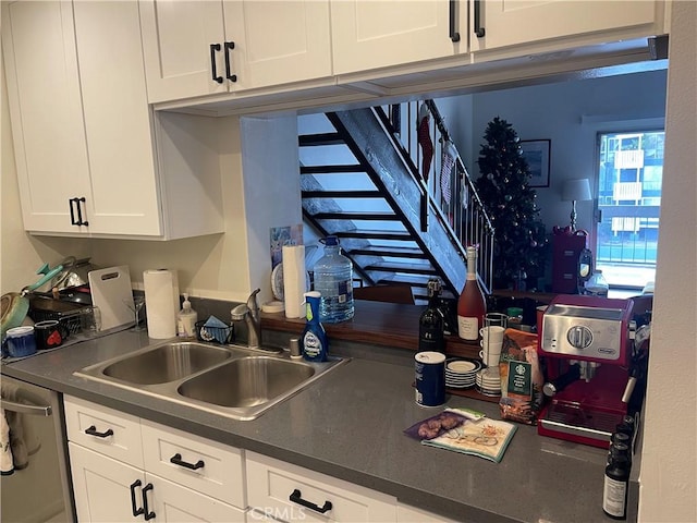 kitchen featuring dishwasher, white cabinetry, and sink