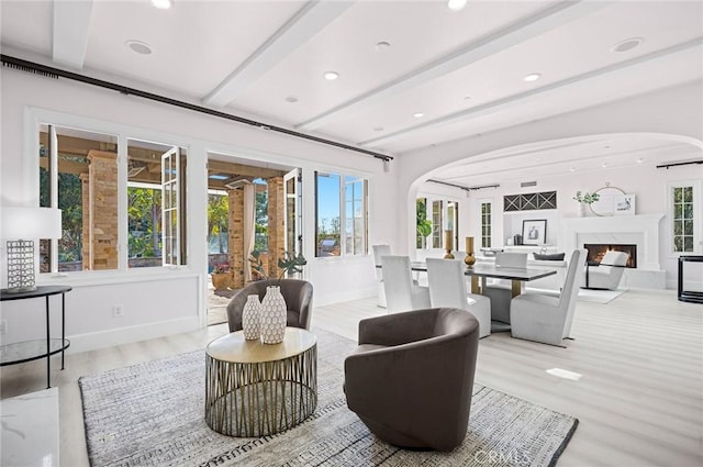 living room featuring beamed ceiling and light hardwood / wood-style floors