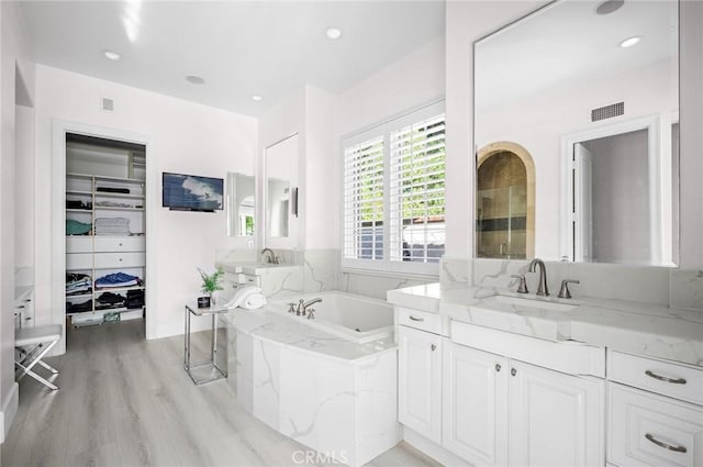 bathroom featuring hardwood / wood-style flooring, a bathtub, and vanity