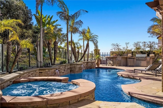 view of swimming pool with pool water feature, area for grilling, a patio area, and an in ground hot tub