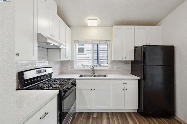 kitchen featuring gas stove, black fridge, white cabinetry, and sink