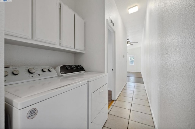 washroom with washing machine and clothes dryer, ceiling fan, light tile patterned flooring, and cabinets