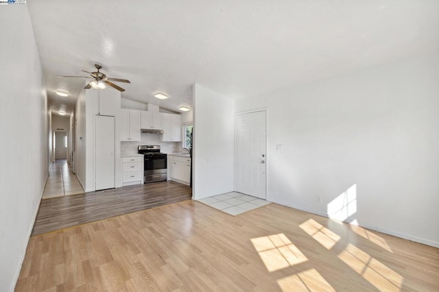 unfurnished living room with vaulted ceiling, light hardwood / wood-style flooring, and ceiling fan