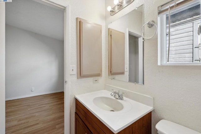 bathroom featuring vanity, wood-type flooring, and toilet