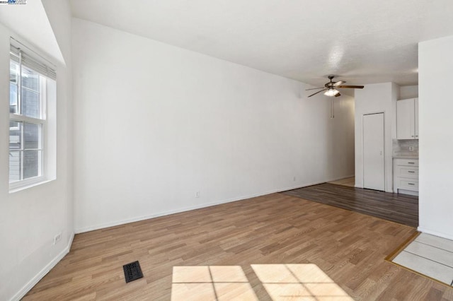 unfurnished living room featuring light wood-type flooring and ceiling fan