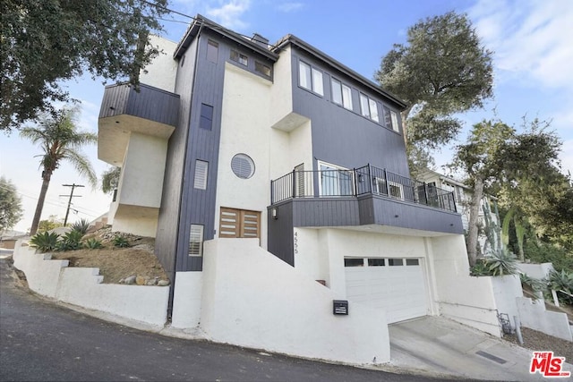 view of front of property with a garage and a balcony