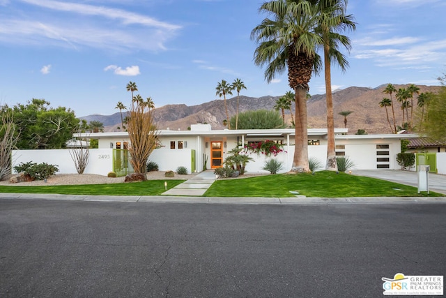 single story home featuring a mountain view and a front yard