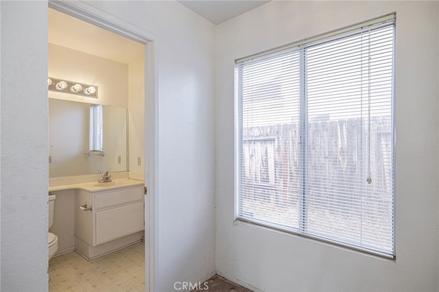 bathroom featuring a wealth of natural light, vanity, and toilet