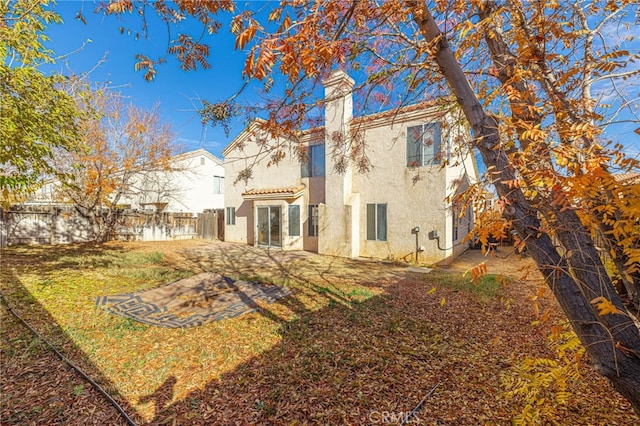 rear view of property featuring a lawn