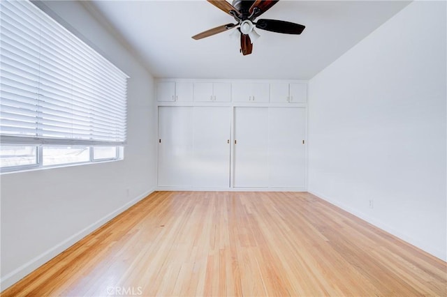 unfurnished bedroom featuring ceiling fan, a closet, and light hardwood / wood-style flooring