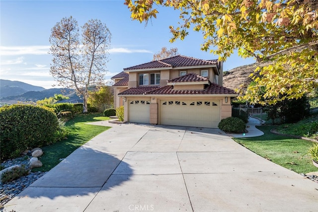 mediterranean / spanish-style home featuring a mountain view, a front yard, and a garage