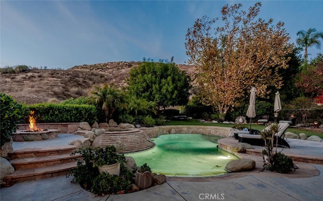 view of swimming pool with a fire pit