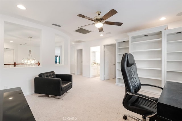 carpeted office space featuring ceiling fan with notable chandelier