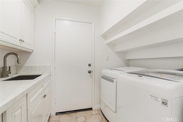 clothes washing area with cabinets, independent washer and dryer, and sink