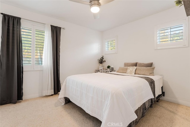 carpeted bedroom with ceiling fan and multiple windows