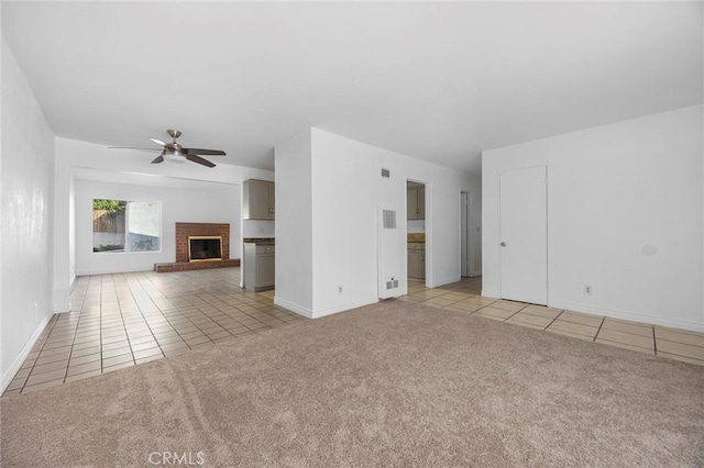 unfurnished living room featuring ceiling fan, light tile patterned floors, and a brick fireplace