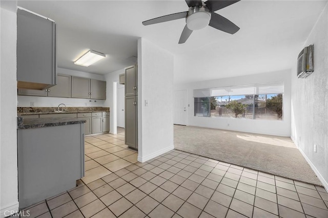 kitchen featuring light colored carpet, ceiling fan, and gray cabinetry