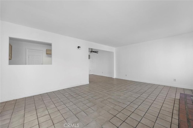 spare room with ceiling fan and light tile patterned floors