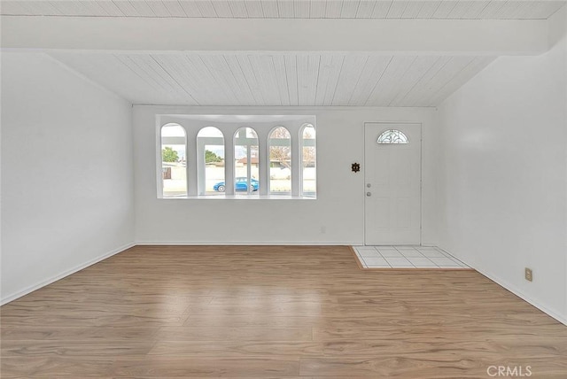 foyer with lofted ceiling with beams, light hardwood / wood-style floors, and wooden ceiling