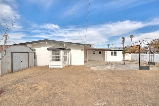 back of property with a gazebo and a storage unit