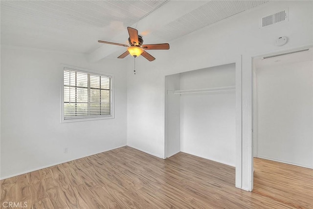 unfurnished bedroom with ceiling fan, beam ceiling, light wood-type flooring, and a closet