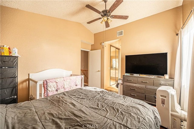 bedroom with a textured ceiling, ceiling fan, and vaulted ceiling