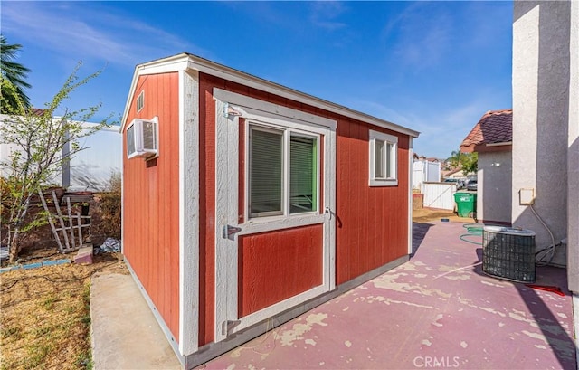 view of outbuilding with central AC unit and a wall mounted air conditioner