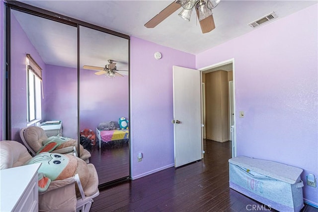 bedroom with dark hardwood / wood-style flooring, a closet, and ceiling fan