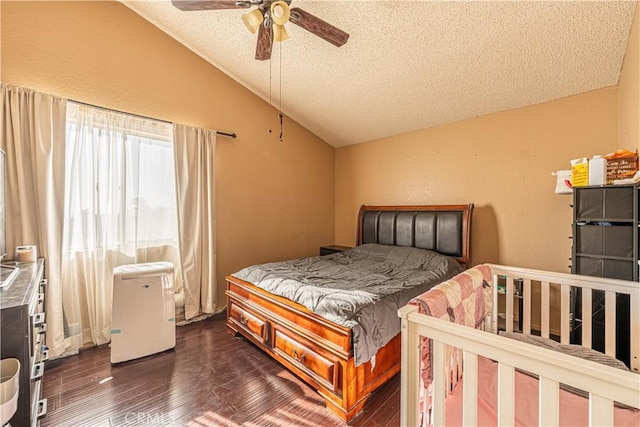 bedroom with a textured ceiling, ceiling fan, dark wood-type flooring, and vaulted ceiling