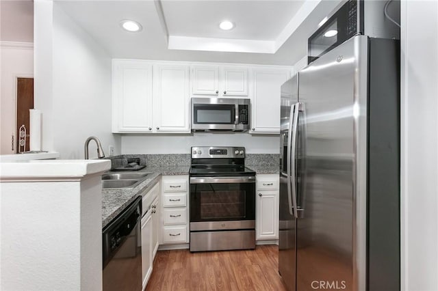 22100 Burbank Blvd Unit 106A, Woodland Hills, CA 91367 - kitchen featuring a sink, stainless steel appliances, a raised ceiling, white cabinetry, and recessed lighting