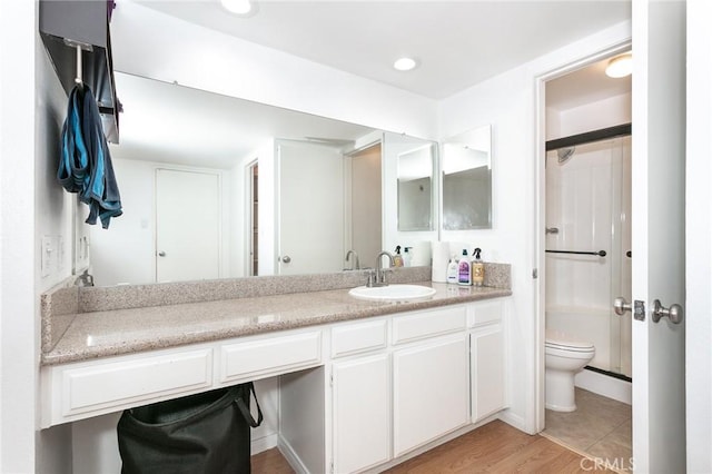 bathroom with vanity, wood-type flooring, and toilet