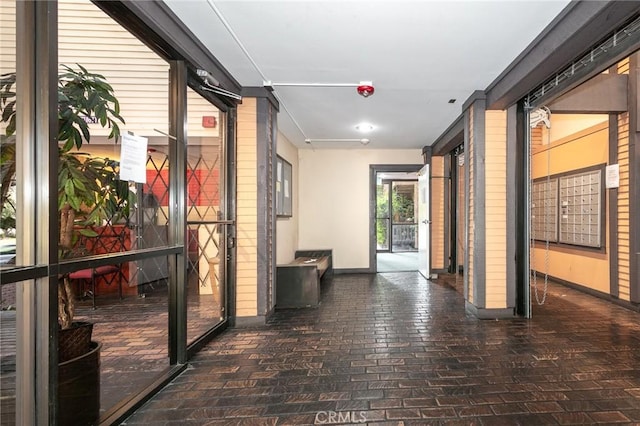22100 Burbank Blvd Unit 106A, Woodland Hills, CA 91367 - hallway featuring brick floor, mail area, and baseboards