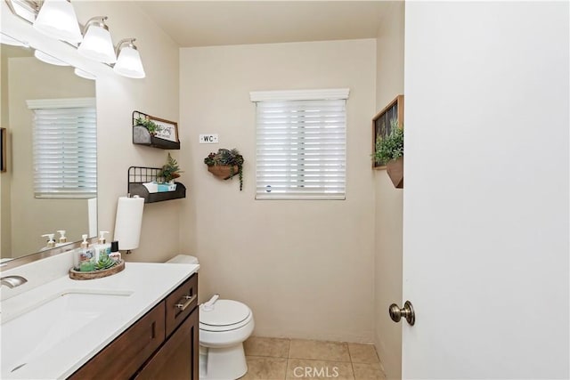 bathroom with toilet, tile patterned flooring, and vanity