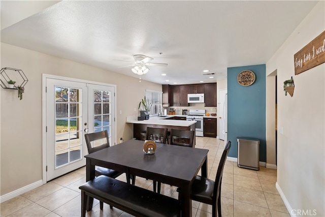 tiled dining area featuring ceiling fan, sink, and french doors