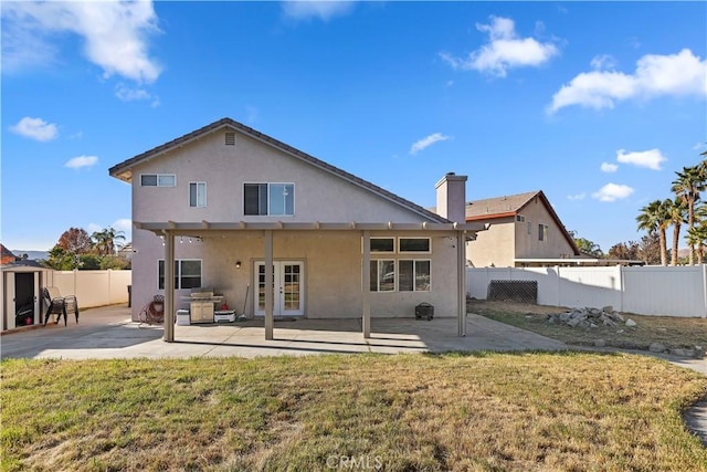 rear view of house with a yard and a patio