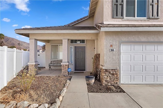 property entrance featuring a garage, a porch, and a mountain view