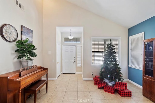 foyer featuring light tile patterned floors and lofted ceiling