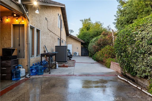 view of side of home with central AC unit and a patio area