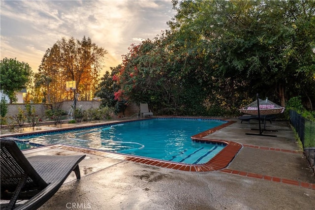 pool at dusk with a patio